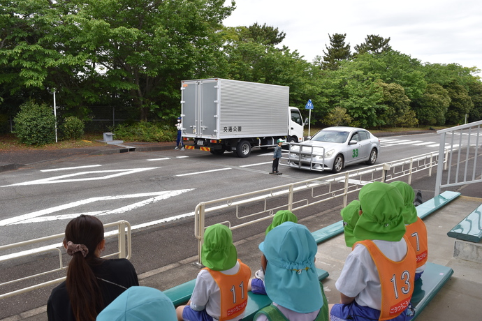 車と衝突するダミー人形を見る園児