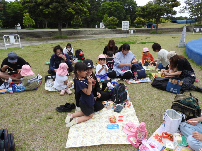 お家の人とお弁当を食べる園児