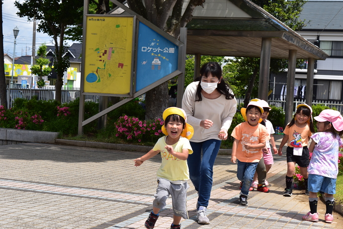 先生と追いかけっこをする園児