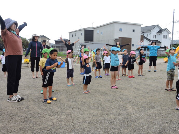 水遊び前の体操をする子供たちの写真