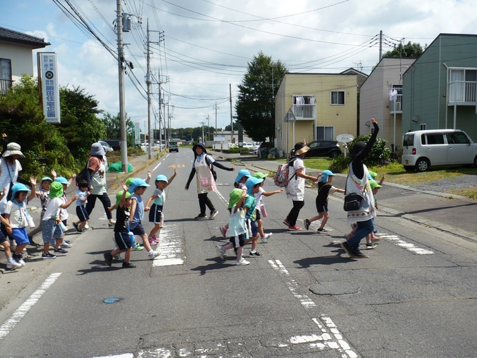 手を挙げて横断歩道を渡っている写真