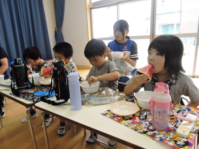 うどんとすいかをおいしそうに食べている写真