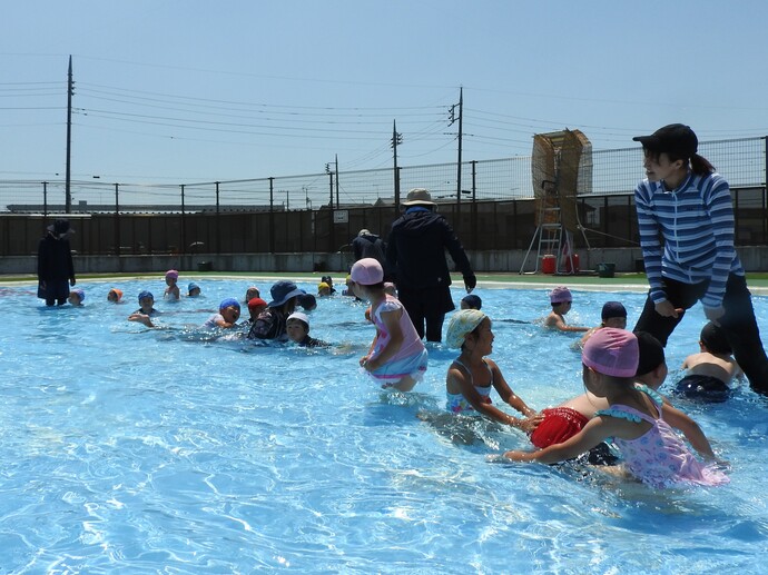 プールで遊ぶ先生と園児