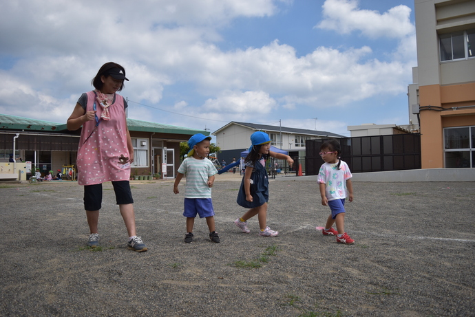 線に並んで走ろうとする園児と先生