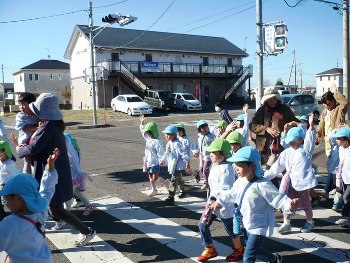 信号のある横断歩道をみんなで渡る写真