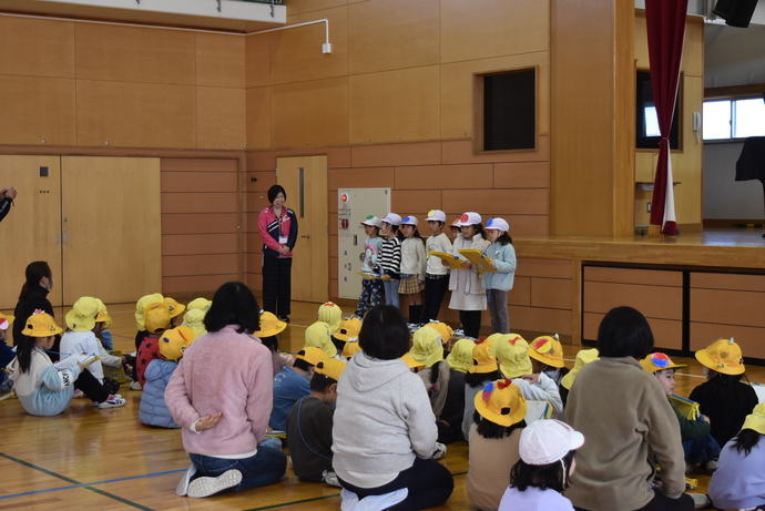 初めの言葉を言う3人の小学生と座って話を聞く子ども達