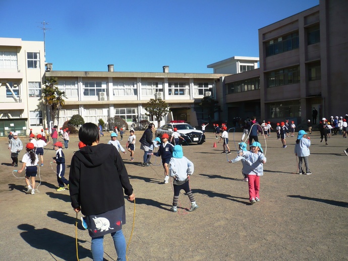 小学校で小学生と一緒になわとびをする写真