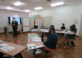 V字に並べた机で、参加者たちが話している写真