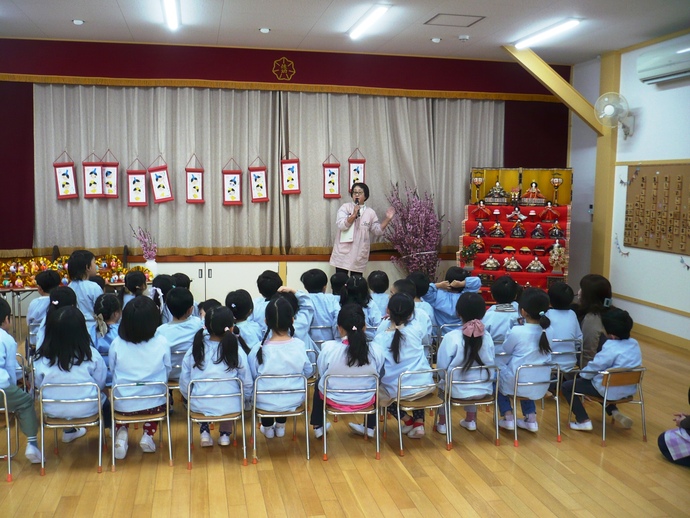 ひな祭り会で先生のお話を聞いてる写真