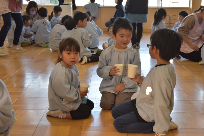 紙コップで飲み物を飲む園児たち