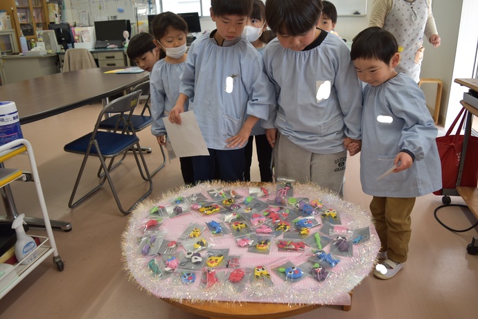 宝物が乗ったテーブルを囲む園児たち