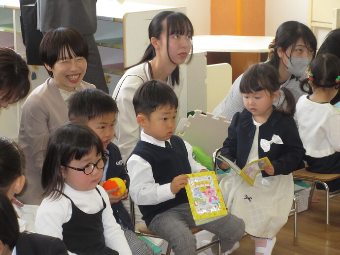 教室で先生の話を聞く園児と保護者