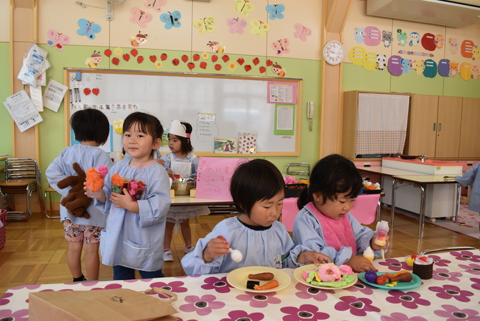 紙粘土のドーナツを食べる真似をする園児達