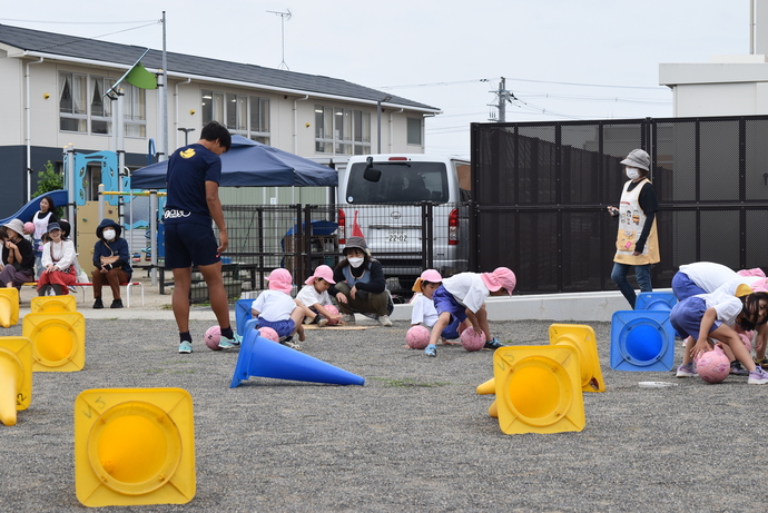 足の間にボールを転がす園児たち