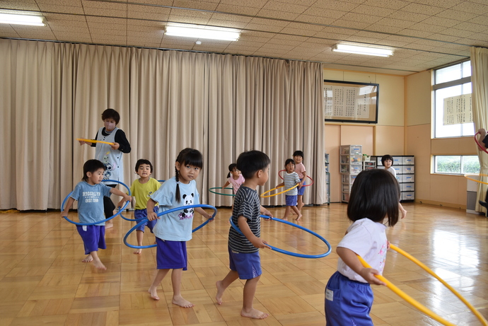 フープの中に入って走る園児たち