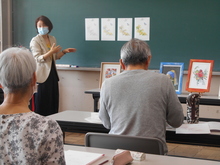 写真：講師が塗り方の説明をしている様子