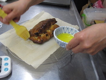 写真：焼きあがりに溶かしバターを塗っている様子