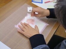 写真:型紙を使って紅葉を描いている様子