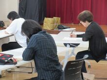 写真:お手本を見ながら「のし袋」に書く文字を練習