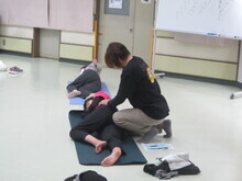 写真:講師が受講者をマッサージしている様子
