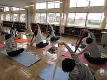 写真:タオルの両端を持って体側を伸ばしている様子