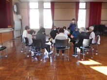 写真:テニスボールを隣の人に渡している様子