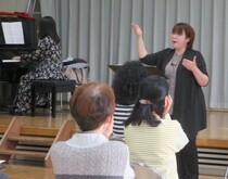 写真：顎に手を当てながら歌っている様子