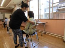 写真：骨盤と背骨の連動を意識した姿勢を講師が指導している様子